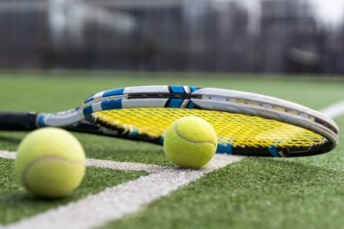 Tenis raketlerini ve tenis kortunda uzanan tenis toplarını kapatın. spor, tenis ve etkinlik