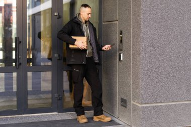 Binanın girişinde kameralı bir adam var.