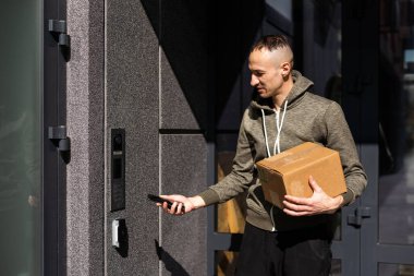 Binanın girişinde kameralı bir adam var.