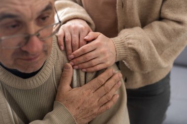 Senior couple, happy and laughing in their home with love, care and support for retirement lifestyle. Commitment of a funny man and woman in a marriage with trust and security on a living room couch