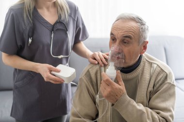 Elderly Senior Man nursing care wear oxygen inhaler device for helping breath respiratory. Oxygen Concentrator portable.