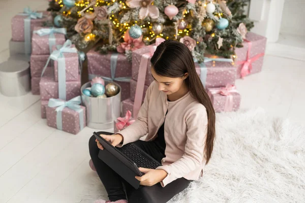 Adolescente Trabalha Casa Remotamente Com Laptop Fundo Uma Árvore Natal — Fotografia de Stock