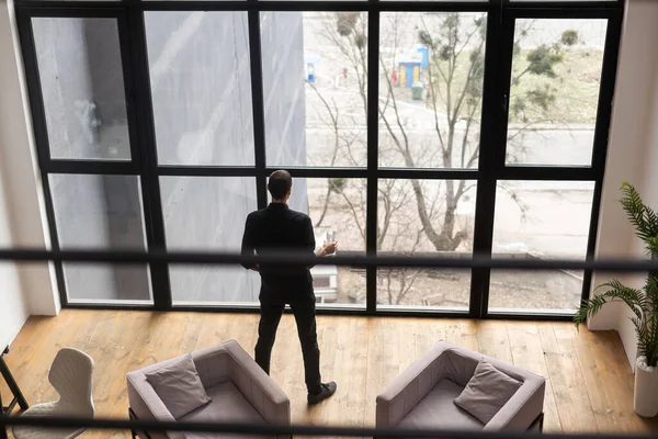 Portrait of young businessman standing outside conference room. Portrait of happy business man wearing spectacles and looking at camera with copy space. Satisfied proud man