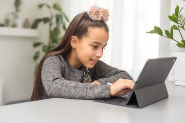 Ev, teknoloji ve internet kavramı. Evdeki tablet bilgisayarla kanepede gülümseyen genç kız..