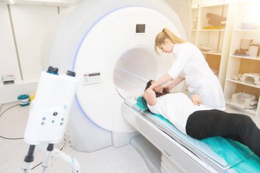 Modern hastane laboratuvarında bir hastaya tıbbi tomografi ya da MRI taraması yapın. Radyografi bölümünün içi. Beyaz odada teknolojik olarak gelişmiş ekipmanlar var. Manyetik rezonans tanılama makinesi.