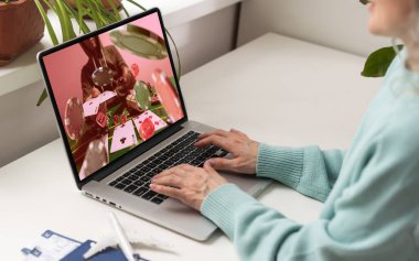 Telefonundaki kumar cep telefonu uygulamasını kullanarak bahis oynarken yakın plan çekimde çekilmiş. Bilgisayarından futbol maçı izleyip kazanmayı bekliyor. Yüksek kalite fotoğraf