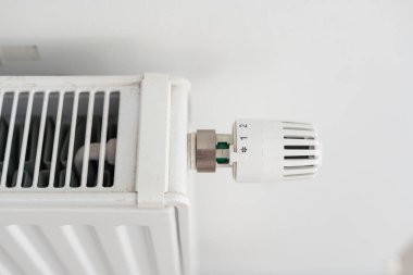 Termoregülasyon binası. Adam radyatör düğmesini çeviriyor. Yüksek kalite fotoğraf