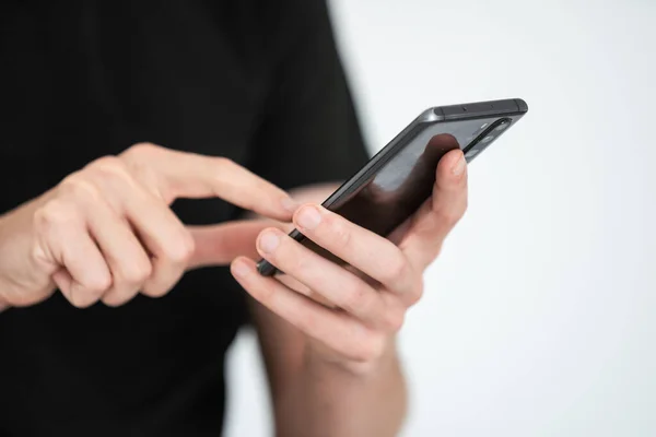 stock image Man presses his finger on the screen of a smartphone on a dark background. High quality photo