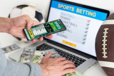 Adam dizüstü bilgisayarında futbol maçı izliyor, favori takımı için tezahürat yapıyor, bahisçilerin internet sitesinde bahis oynuyor. Yüksek kalite fotoğraf
