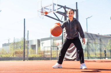 Şehrin arka planında basketbol topu olan bir kız. Sokak basketbolu