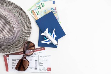 Beyaz arka plan görünümlü pasaport ve şapkalı turistik şeyler.