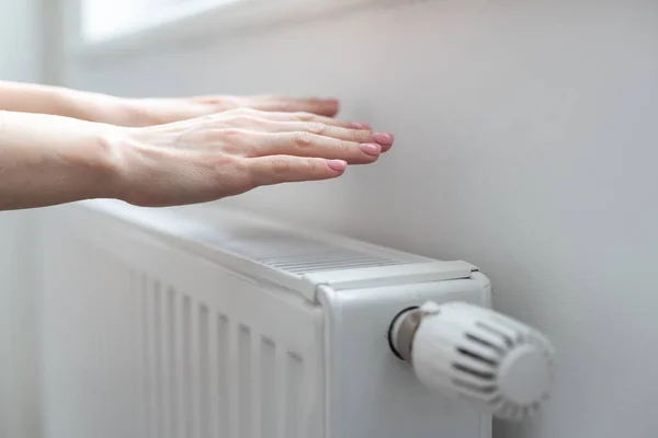 Womans hand adjusting radiator temperature. High quality photo