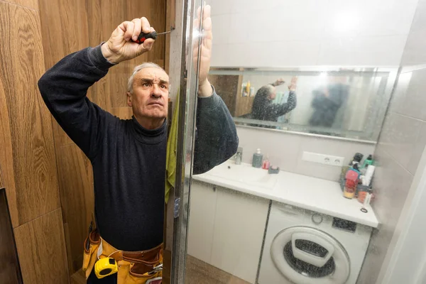 Elderly Man Repairing Door Shower Cabin Bathroom — 스톡 사진