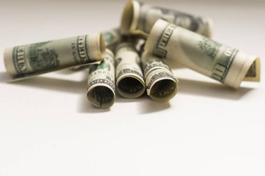 Roll of 100 dollar bills on background.