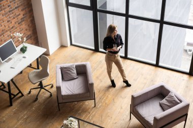 pretty, young and blond woman stylish in a sustainable office.