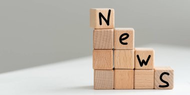 Gri arkaplandaki ahşap harflerden düzenlenmiş NEWS metni. Yüksek kalite fotoğraf