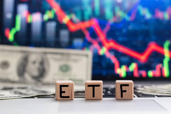  ETF - биржевой текстовый фонд на деревянных кубиках, кубики лежат на финансовой карте. Высокое качество фото