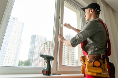 Elinde tornavida olan usta pencereye düzenek kuruyor. Yüksek kalite fotoğraf