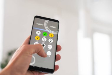 Akıllı bir evle ev ısısını kontrol etmek, telefonla yakın çekim yapmak. Evdeki akıllı cihazları yönetmek için akıllı ev ve mobil uygulama kavramı. Yüksek kalite fotoğraf