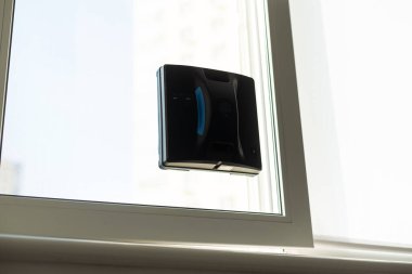 Beyaz robotik pencere temizleyicisi temizlik için bir fırça ve süpürge kullanır. Otomatik pencere temizleyicisi ev işleri için çok yardımcı oluyor. Yüksek kalite fotoğraf