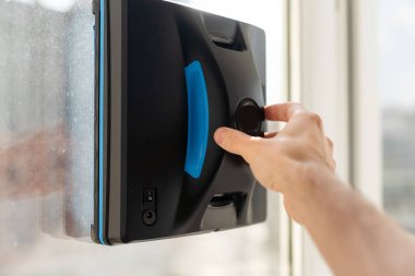 Beyaz robotik pencere temizleyicisi temizlik için bir fırça ve süpürge kullanır. Otomatik pencere temizleyicisi ev işleri için çok yardımcı oluyor. Yüksek kalite fotoğraf