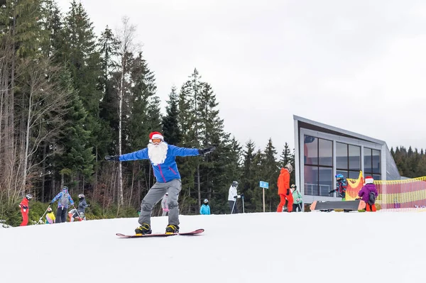 Kerstman Met Snowboard Tegen Besneeuwde Winter Bergskigebied Landschap Blauwe Lucht — Stockfoto