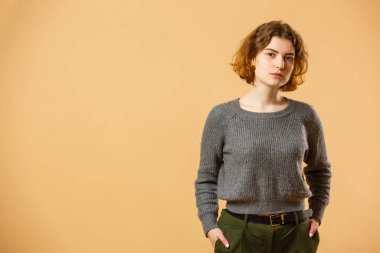 Portrait of young beautiful cute cheerful girl smiling looking at camera over beige background