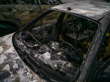 Otoparkta kırık ve yanmış arabalar, kaza ya da kasıtlı vandalizm. Yanmış araba. Bir araba kazasının sonuçları. Kundaklama yüzünden zarar görmüş. Rus birlikleri tarafından Ukrayna 'da vurulan sivil araçlar.