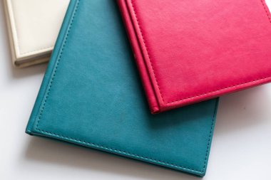 Ahşap bir masa ve bej bir duvarın üzerinde katlanmış ve kapanmış beyaz kitaplar var. Yüksek kalite fotoğraf