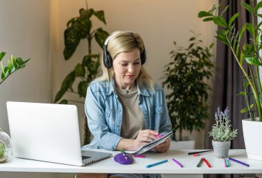 Pretty female student with cute smile keyboarding something on net-book while relaxing after lectures in University, beautiful happy woman working on laptop computer.