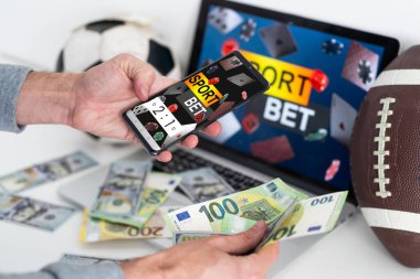 Genç ve çekici sakallı bir adam favori takım zaferi için samimi bir heyecan gösteriyor. Adam cep telefonuyla online spor kumar uygulamasında bahis kazanmaktan mutlu. Yüksek kalite fotoğraf