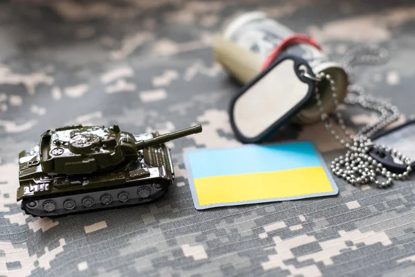 Military ID tags and patch on pixel Ukrainian camouflage, closeup no war. High quality photo
