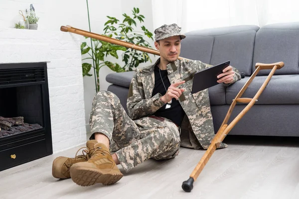 military man on crutches with tablet doctor.