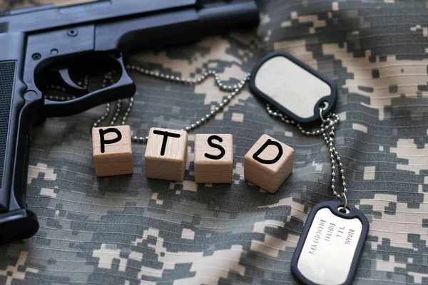 the word PTSD laid with silver metal letters on flat rusted steel sheet background in slanted diagonal perspective. High quality photo