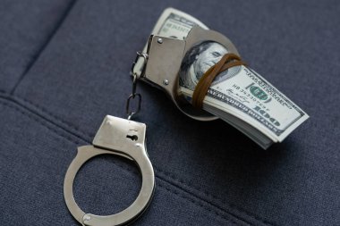 Kelepçeler yüz dolarlık banknotların üzerinde. Güç ve rüşvet. Suçlu fidyesi. Suçlu kazancı. İş konsepti. Zenginlik kavramı. Yüksek kalite fotoğraf