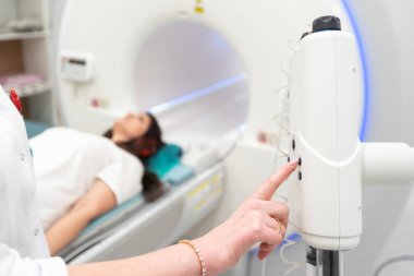 Modern hastane laboratuvarında bir hastaya tıbbi tomografi ya da MRI taraması yapın. Radyografi bölümünün içi. Beyaz odada teknolojik olarak gelişmiş ekipmanlar var. Manyetik rezonans tanılama makinesi.