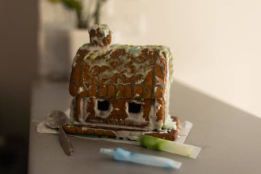 Masa örtüsü ve süslemeleri olan el yapımı zencefilli kurabiye evi. Tatil havası..