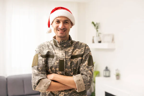 portrait of military man in santa hat looking at camera and funny emotion