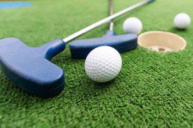 Mini golf sopaları ve farklı renkte toplar suni çimlerin üzerine konmuş. Yüksek kalite fotoğraf