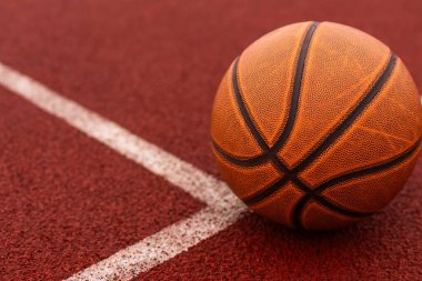 Spor salonunun kahverengi sahasında turuncu basketbol. Sokak basketbolu kavramı. Yüksek kalite fotoğraf