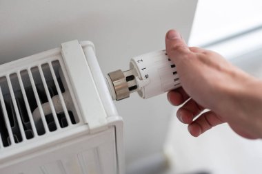 Mans iç ısıtma sisteminin yönetmelik topuzunu tutuyor. Yüksek kalite fotoğraf