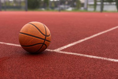 Basketbol topu yere düştü. Kırmızı sahada yakın çekim topu. Sokakta ya da kapalı sahada basketbol. İnsansız spor malzemeleri. Minimalizm. Şablon, spor geçmişi. Yüksek kalite fotoğraf