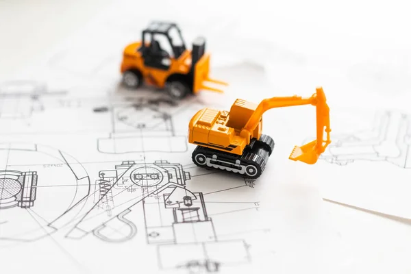 tractor toy on housing construction blueprint. High quality photo