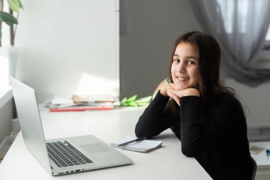 Bilgisayarda öğretmenle video kameraya dahil olan gülümseyen liseli genç kız çevrimiçi sınıfta uzaktan eğitim dersi dinliyor. evde eğitim kavramı