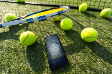 spor, fitness, teknoloji, oyun ve nesneler konsepti - ahşap zeminde top ve tablet bilgisayar ile tenis raketine yakın çekim. Yüksek kalite fotoğraf