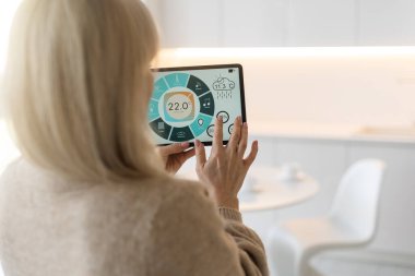 Bir tablet ile akıllı ev perde tutan bir kadın.