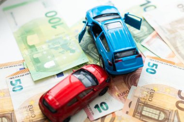 Avrupa banknotlarının arka planında iki oyuncak arabanın trafik kazası. Yüksek kalite fotoğraf