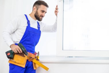 servis elemanı tornavidayla pencere kuruyor.