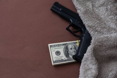 Nakit dolarların arka planında siyah silah. Para ya da para karşılığı cinayet kavramı. Banka soygunu. Yüksek kalite fotoğraf