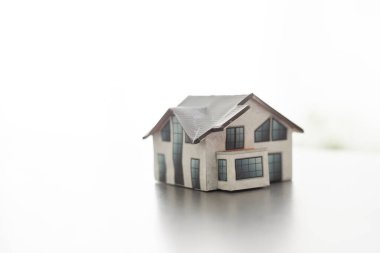 Arka planda küçük bir ev modeli.